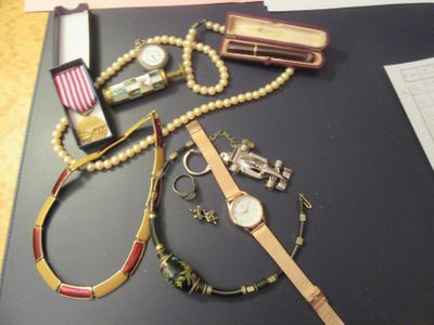 une table sur laquelle sont posées une montre, des bracelets et d'autres objets