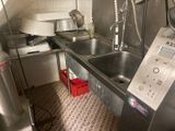 une cuisine équipée d'un évier, d'une cuisinière et d'autres appareils électroménagers