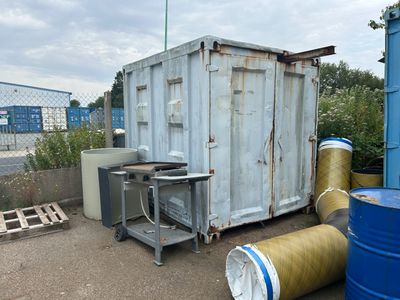 a blue container sitting next to two barrels and a table