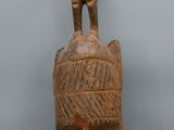 une image représentant une sculpture en bois d'un homme coiffé d'un chapeau
