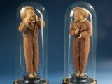 two figurines of a man and a woman under a glass dome