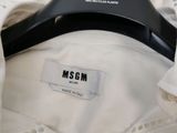 a white shirt that has a black hanger on it