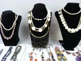 several necklaces and bracelets are displayed on display on a table
