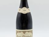 une vieille bouteille de vin posée sur une table blanche