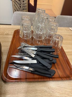 a tray with knives and glasses on it on a table