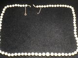 un collier de perles blanches sur un fond noir