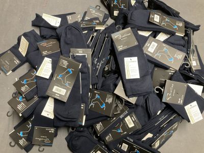 a pile of men ' s black pants with tags on them