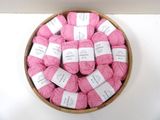 de nombreuses pelotes de laine rose dans un saladier posé sur une table