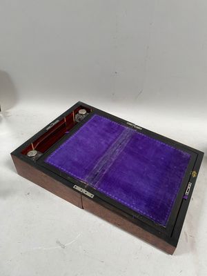 une petite boîte avec un couvercle violet et un verre de vin à côté