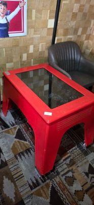 a red table with a glass top in a living room