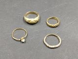 trois bagues en or et une bague avec une pierre au centre