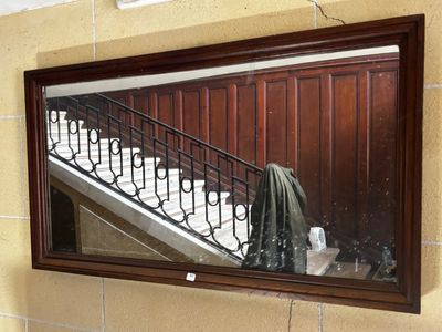 un miroir sur le mur au-dessus d'un lavabo dans une salle de bains