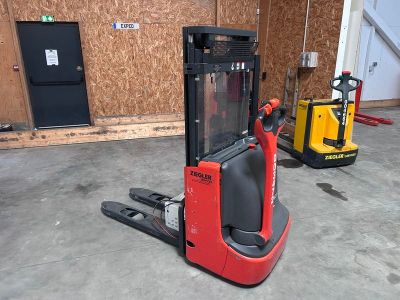 un chariot élévateur garé dans un garage à côté d'un autre chariot élévateur