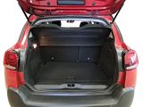 the back of a red car with its trunk open and the back door open