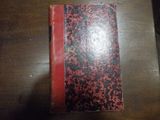 un livre rouge et noir posé sur une table en bois