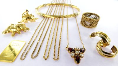 a lot of gold jewelry on a white table