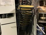 une pile de chaises et un réfrigérateur dans une pièce