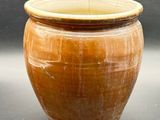 un grand pot marron posé sur une table