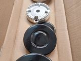 four black plates in a cardboard box on a table