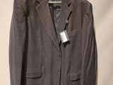 the jacket is hanging on a hanger on the wall