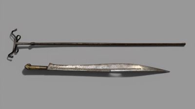 an old dagger and a sword on a gray surface