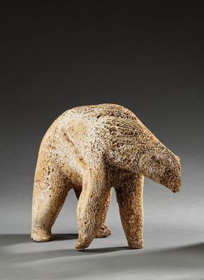 une petite statue représentant un ours debout sur ses pattes arrière