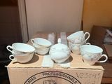 six cups and a saucer in a box on a table