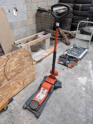 une photo représentant un cric de sol et une palette dans un garage