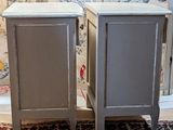 two nightstands sitting on a rug in front of a wallpapered wall