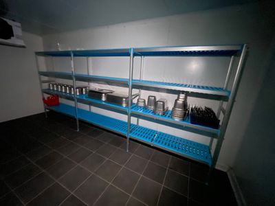 une étagère bleue sur laquelle sont posés des casseroles et des poêles