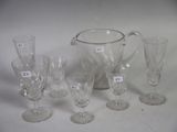 a lot of glasses and a pitcher sitting on a table