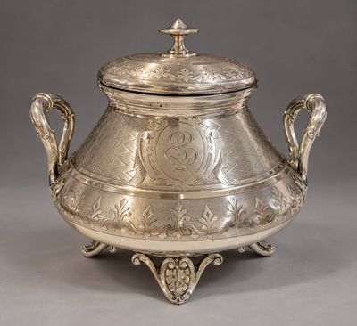 an antique silverplated teapot with a lid on a stand