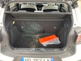 the trunk of a car with a seat folded open and a plastic bag in the trunk