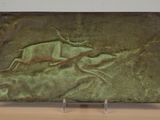 sculpture of a deer and a bird on a green background