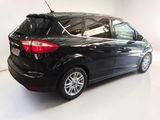 the back end of a black ford c - max parked in a white room