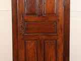 an old wooden cabinet with a door on top of it in a room
