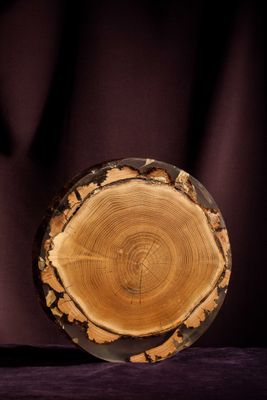 a wooden plate sitting on top of a purple cloth