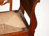 an old wooden chair with a seat made of wood and a seat made of rope
