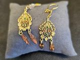 un gros plan sur une paire de boucles d'oreilles posées sur un oreiller