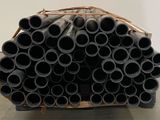 a pile of black pipes sitting on a pallet