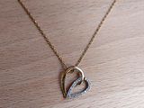 un collier en or orné d'un cœur en diamant