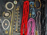 various necklaces and bracelets are displayed on a black surface