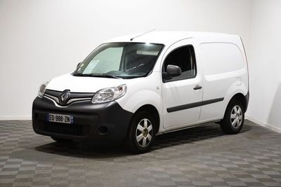 une camionnette blanche garée dans une pièce au sol en damier