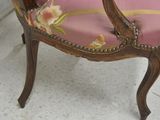 a pink chair with a floral pattern on the back of it