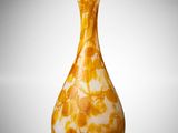 an orange and white vase sitting on top of a white surface