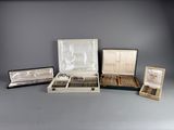 several different types of silverware in a case on a gray surface