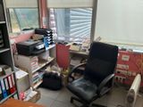 a black office chair sitting in front of a computer desk