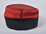 a red hat with black trim on a white surface