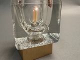 a small glass candle holder with a light bulb inside of it