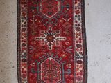 a red and blue rug on a white floor